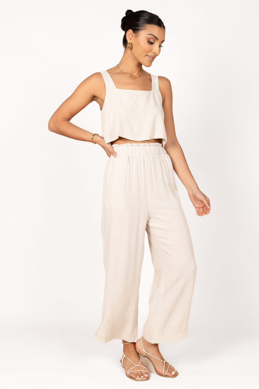 a tan crop top, tan wideleg pants, an oversized white shirt, creamy sandals  and statement earrings for co…